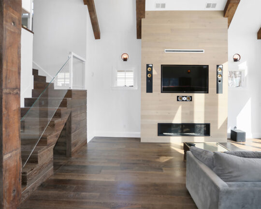 Unique interior of living room and staircase with dark brown accents, neutral colors, and rich dark brown flooring