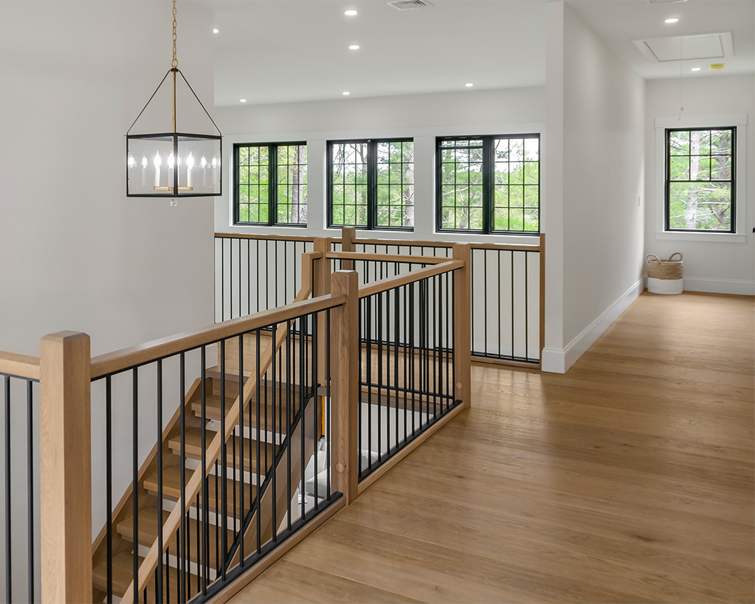 Modern staircase design with brown wood flooring.