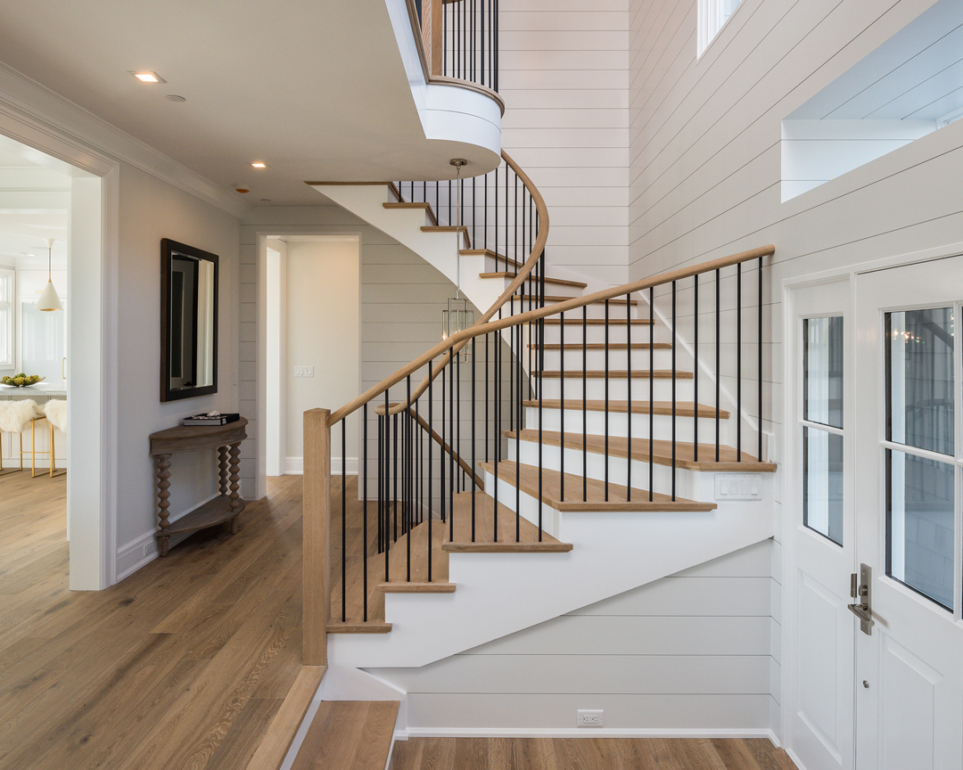 Spiral staircase with wooden treads and matching wood flooring.