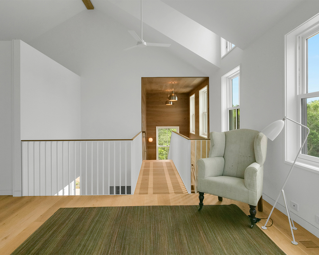 Simple, modern design with light colored wood floor, white walls, and wood paneled walls around staircase.