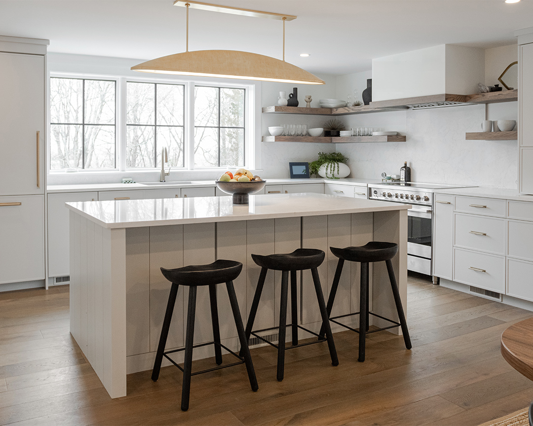 Stylish and modern kitchen with white island and cabinets on top of a clean wood floor