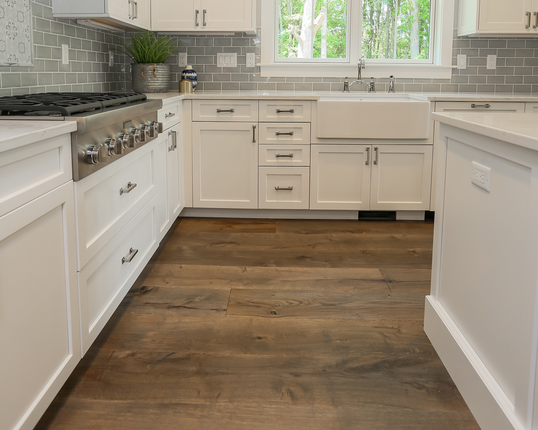 Kitchen with white cabinets and dark brown wood flooring.