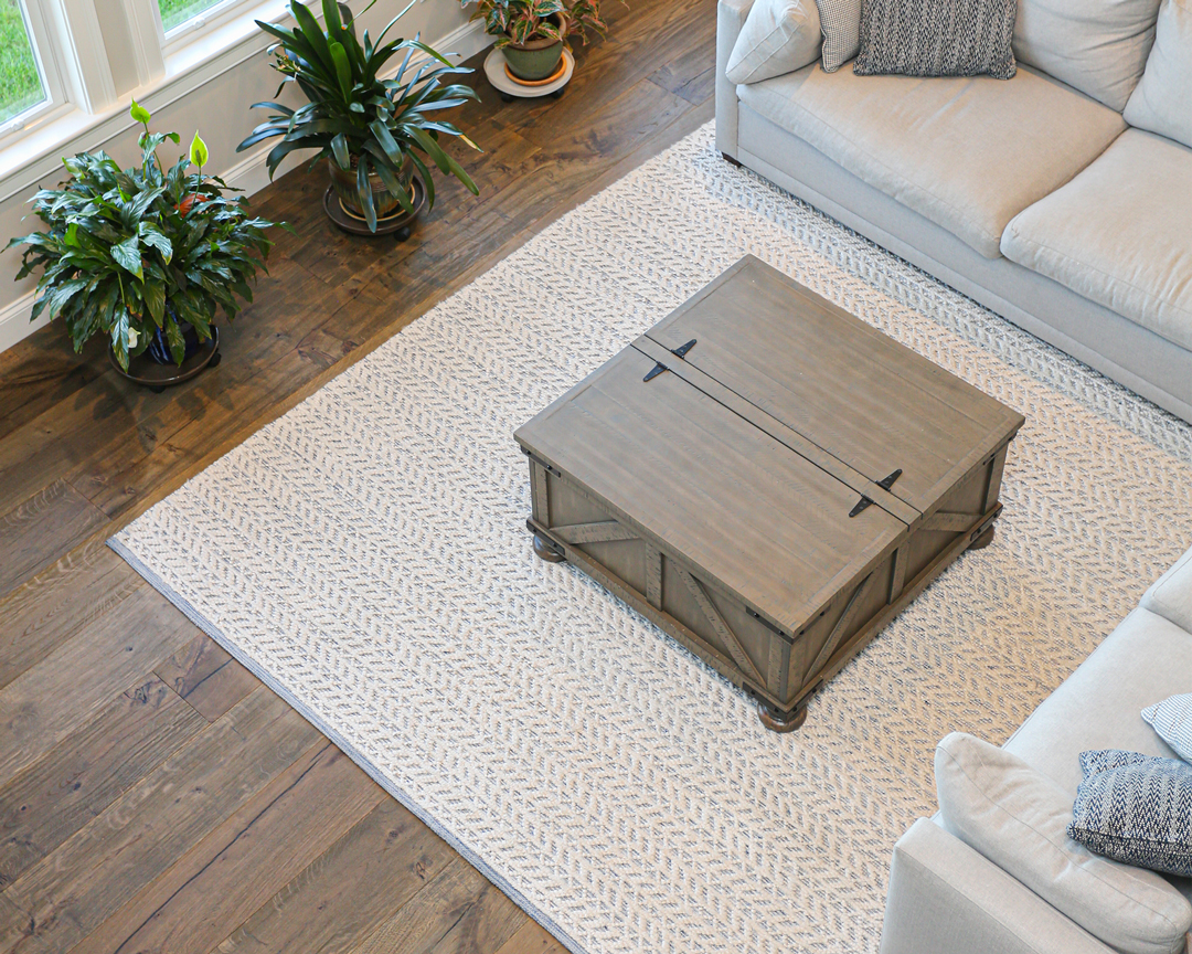 Living room with gray furniture and carpet on dark brown wood flooring.