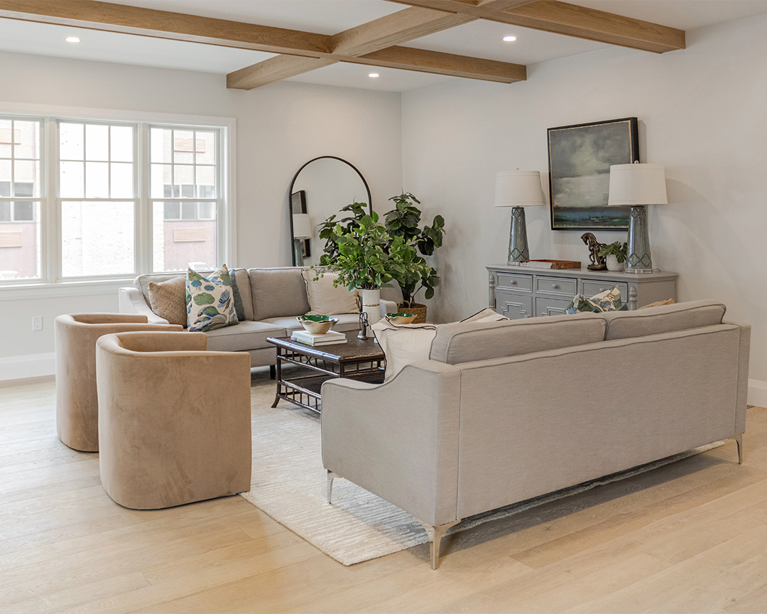 Living room designed with neutral colors, bright windows, and a wide plank matte finished floor