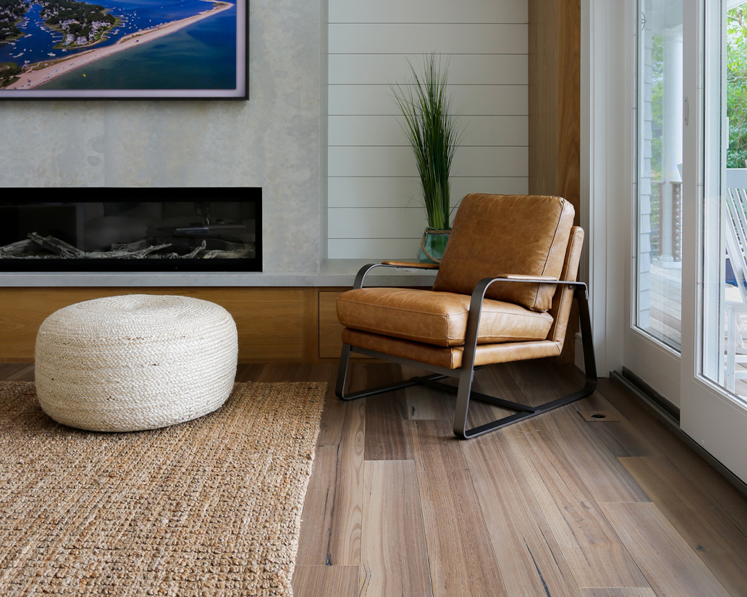 Living area with leather chair, decorative accents, and matte finished wood floor