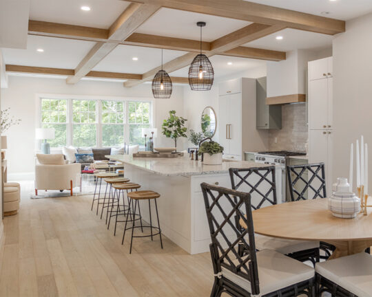 Lively kitchen design with decorative plants, white colors, box beams on the ceiling, and french oak flooring