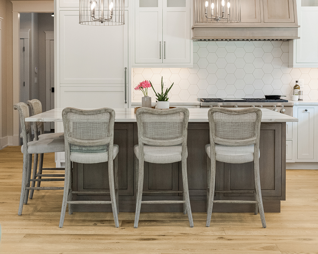 Elegant kitchen design with floral decor, island and dining chairs, and a wide plank wood floor