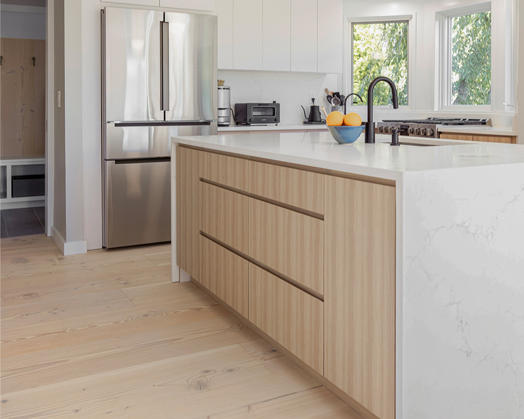 Kitchen with white marble accents and light colored wood floor.