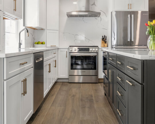 Dark wood floors with white cabinets and gray island.