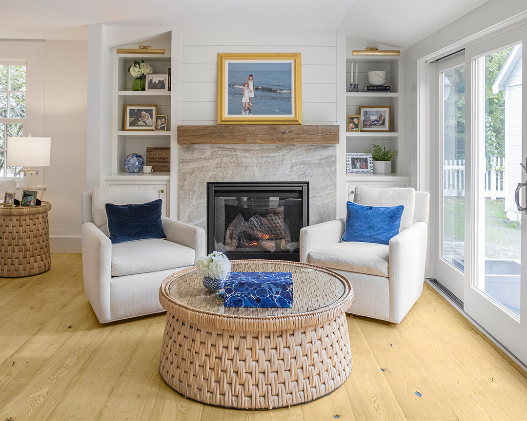 Coastal living room with neutral colors and blue accents, decorated with a matte-finished wood floor
