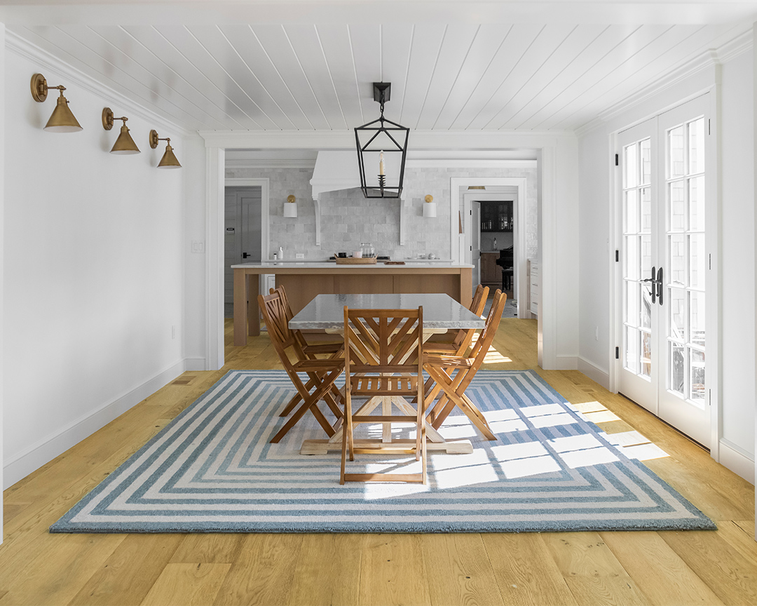 Unique dining room with area rug and wide plank flooring.