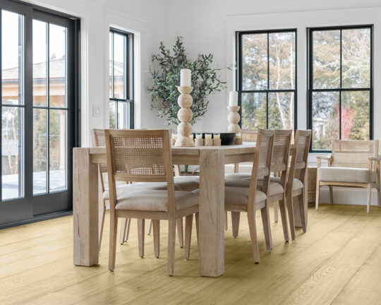 Rustic dining room with tall windows and bright wood flooring.