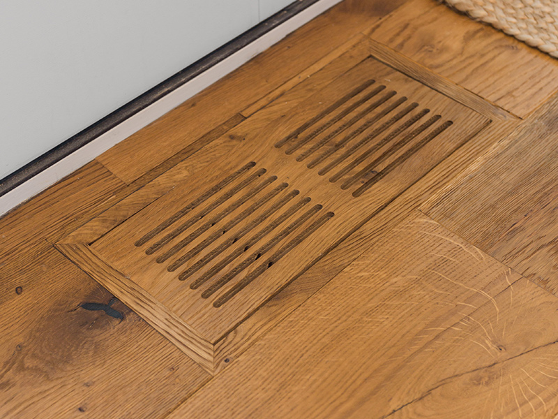 Flush mount air grille color coordinated with wood flooring.