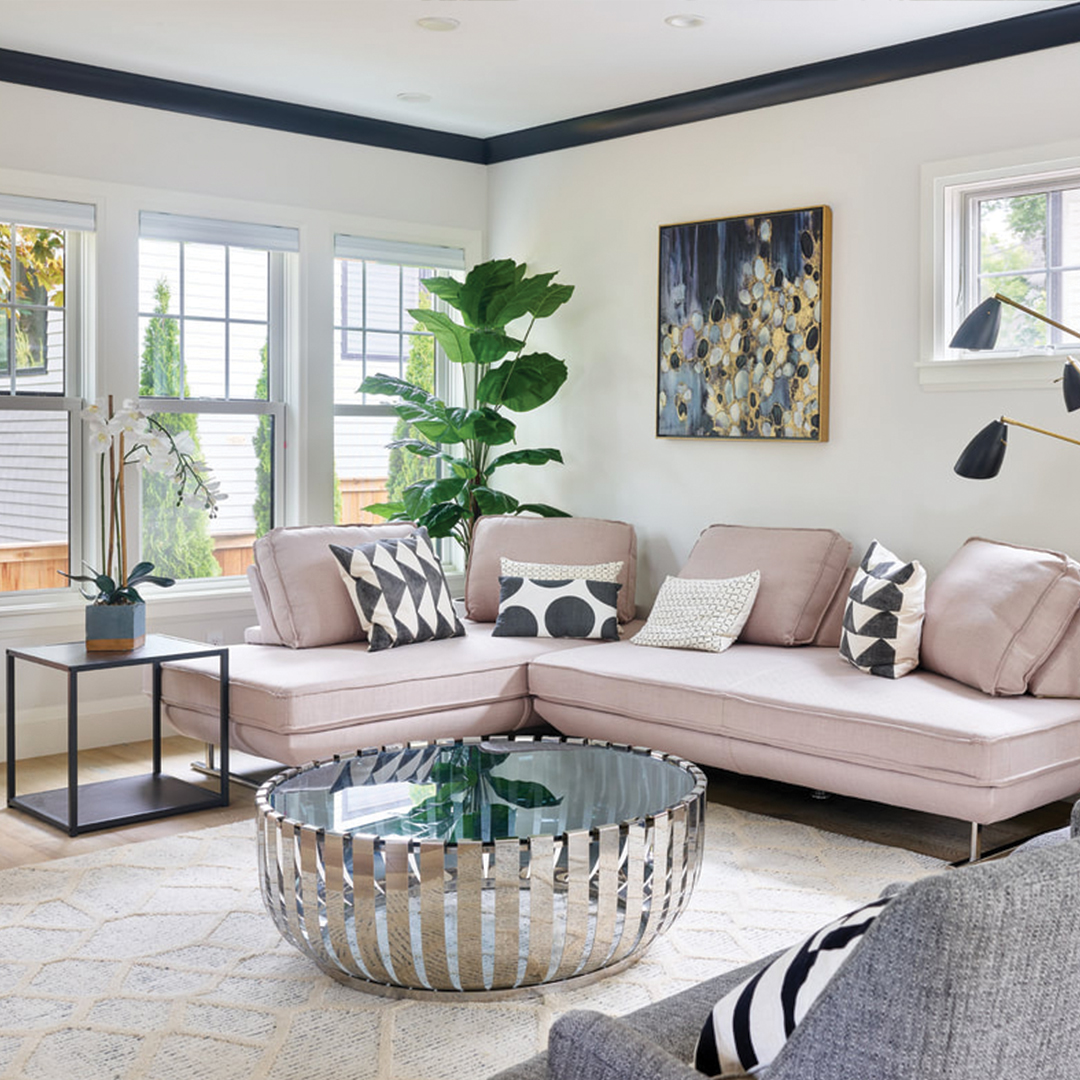 Well decorated living room with plants, painting, unique coffee table, and white carpeted floor.