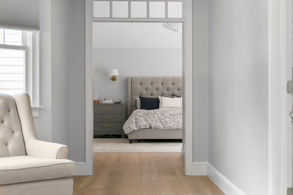 Open doorway with neutral colored bedroom in the distance, with sustainable wood flooring.