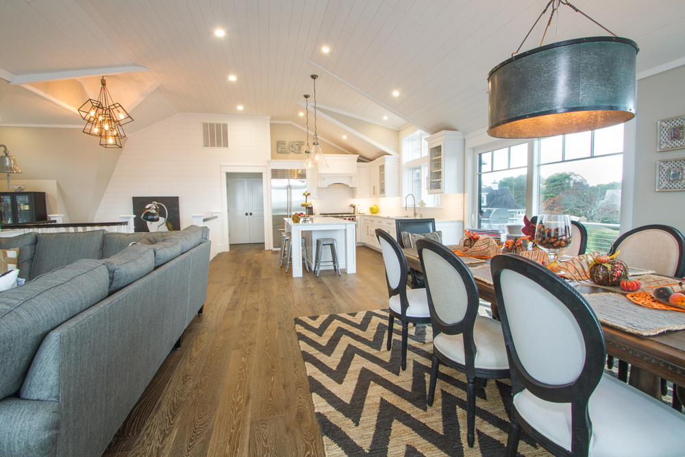 Kitchen and dining room with harvest decorations, unique striped area rug, and a dark brown wood floor.
