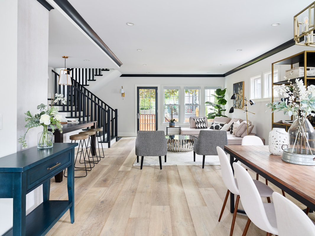 Dining area with living room in distance with light colored wood flooring.