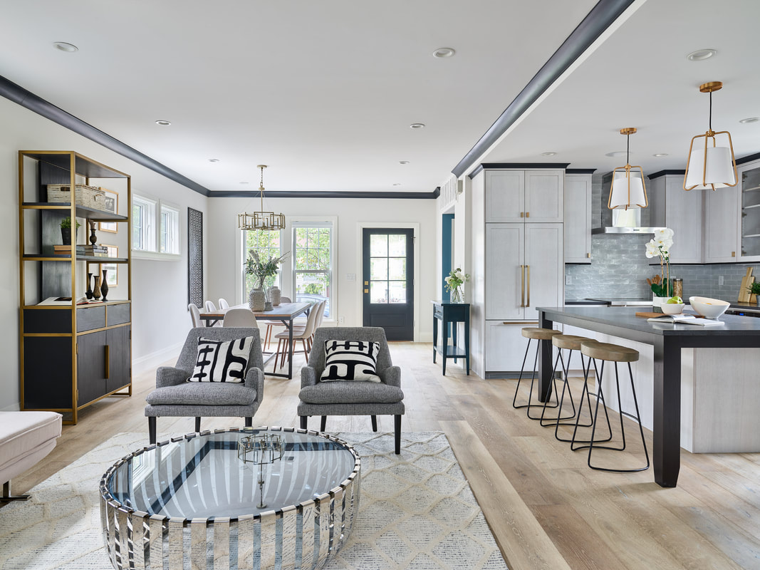 Extensively decorated sitting area, kitchen, and dining room with a beautiful wide plank wood floor.