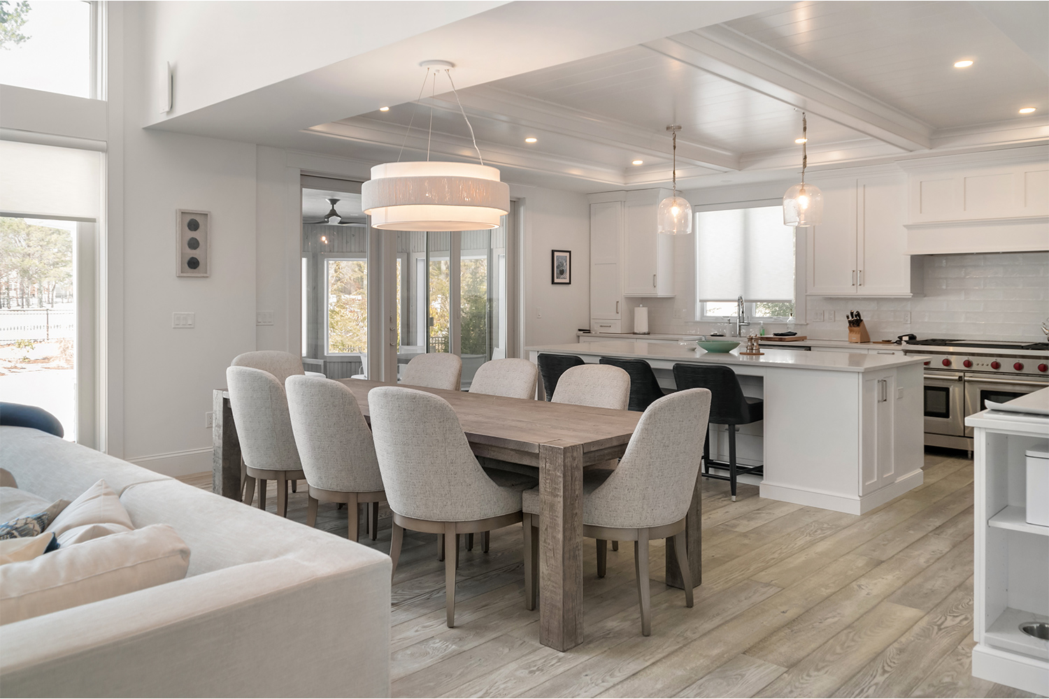 Neutral colored kitchen and dining room with gray toned wood flooring.