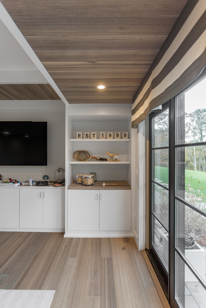 Living room with wood paneled ceiling and matching gray toned wood floor.