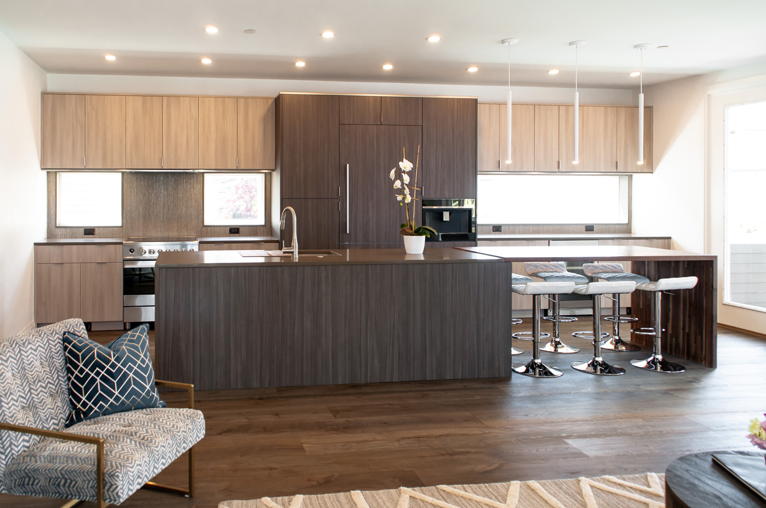 Mid century modern kitchen with unique island and stools and dark brown wood flooring.