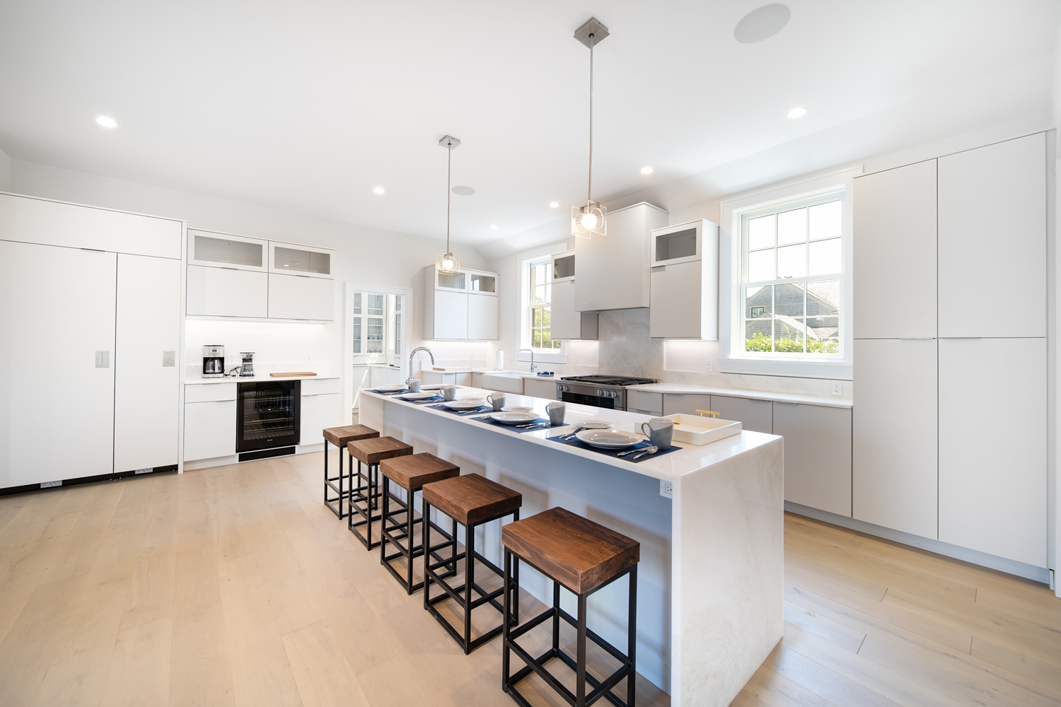 Clean, modern kitchen design with white cabinets and light colored wood floor.