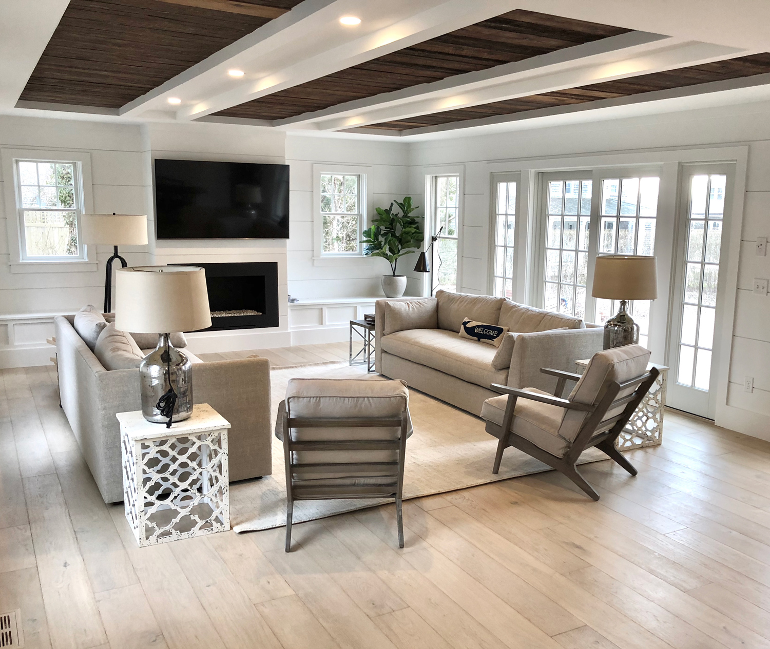Beachy living room with grays and neutrals with sand colored wood flooring.