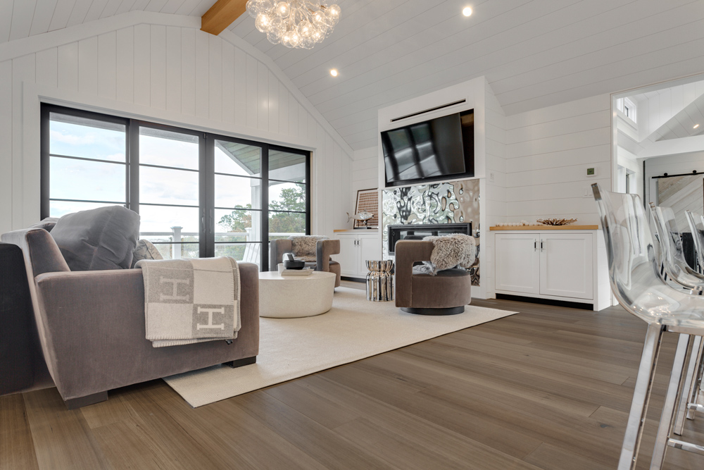 Modern living room with gray furniture and gray toned wood flooring.