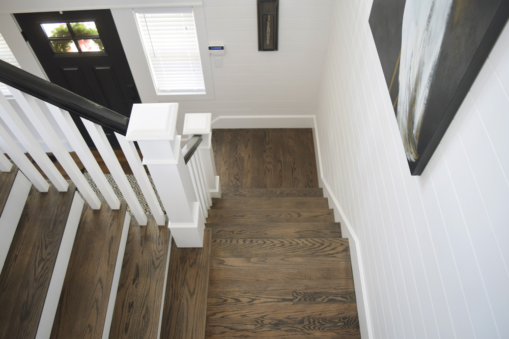 Top down shot of staircase with dark brown wood flooring and matching stair treads.