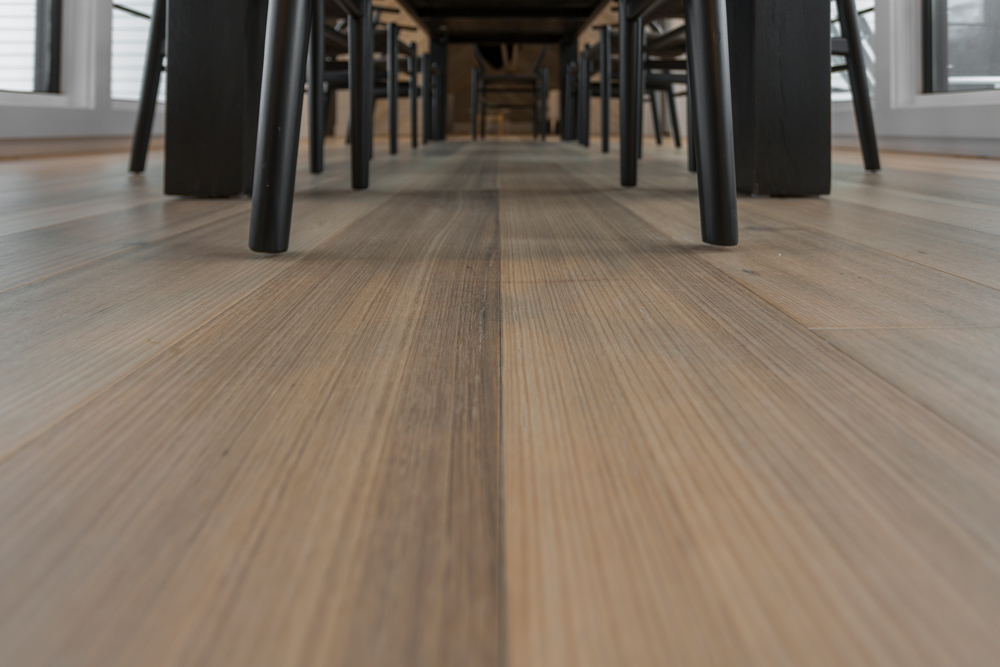 Close up of wood flooring with wire-brushing and gray tones.