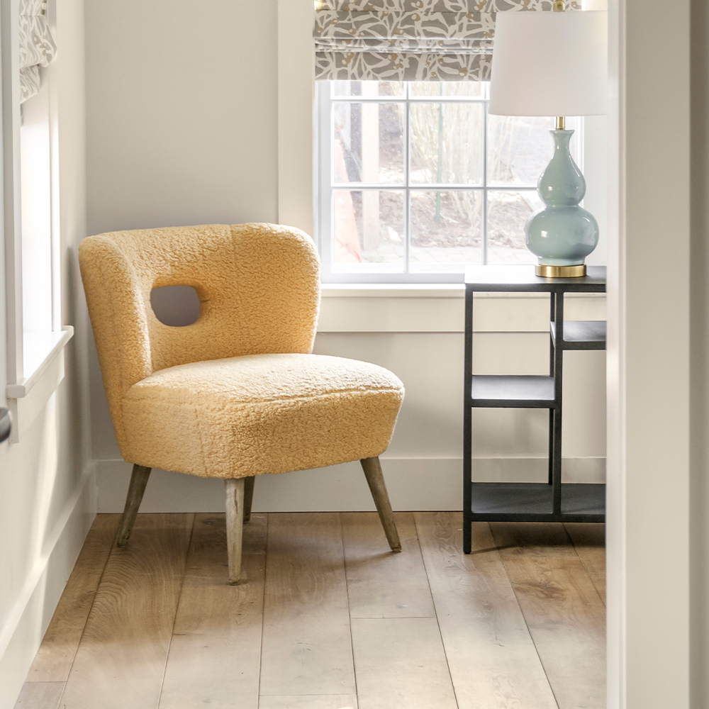 Cozy nook with chair and end table with a sustainable wood floor.