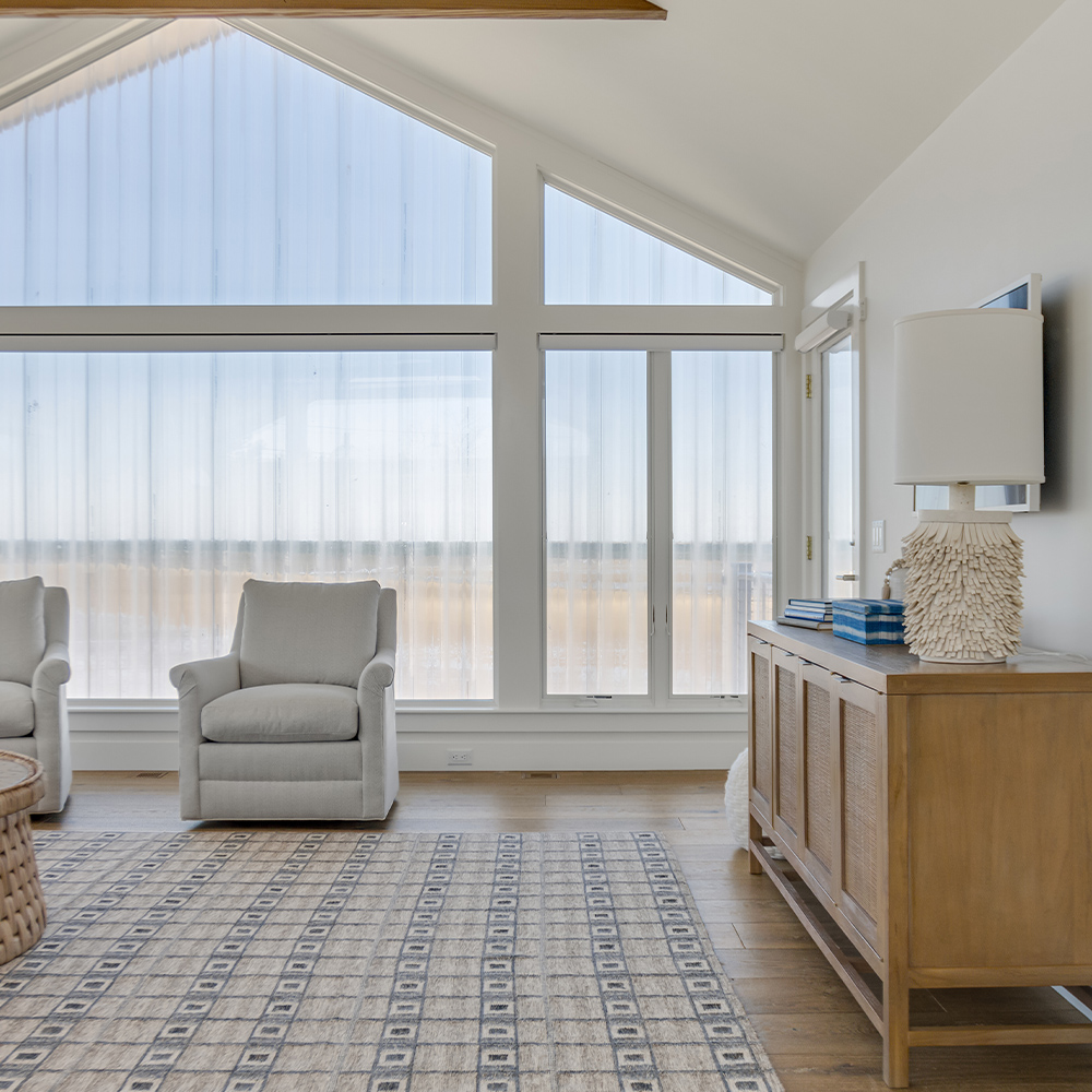 Family room with giant windows and wood flooring.
