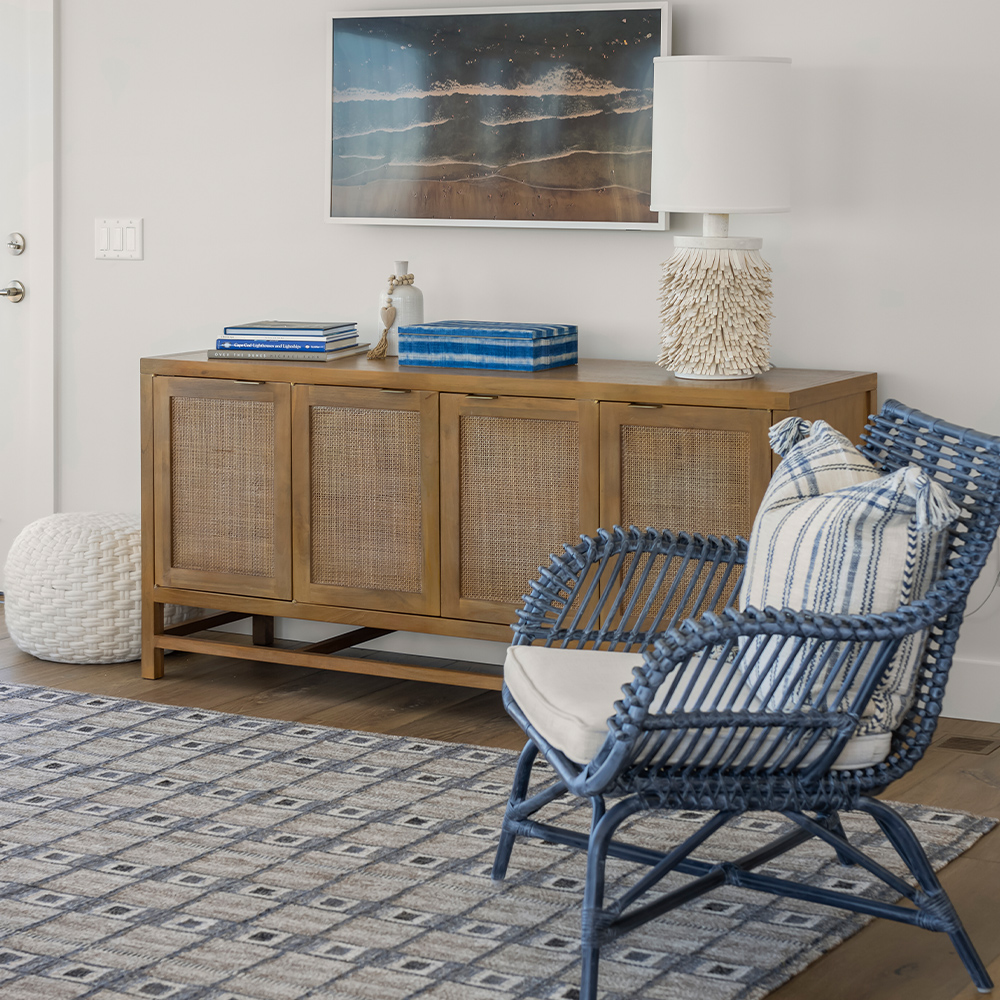 Cozy sitting area with carpet, chair, credenza, and wood floor