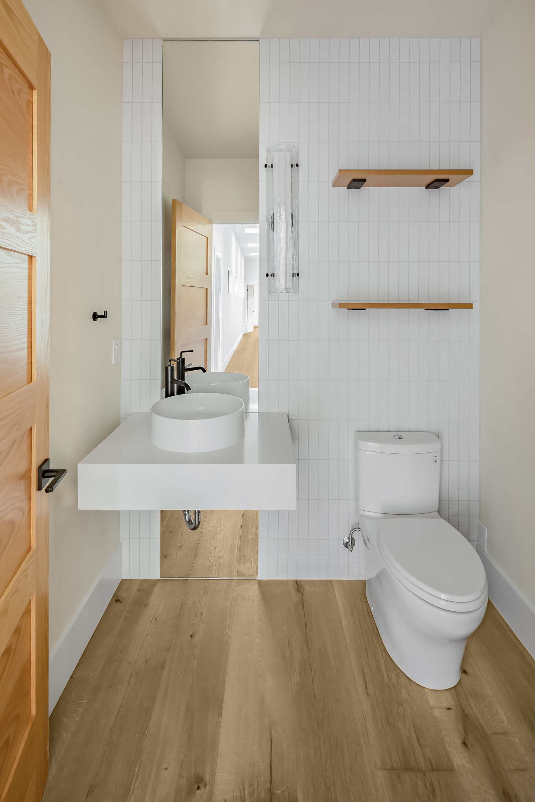 Unique bathroom design with wide plank wood flooring.