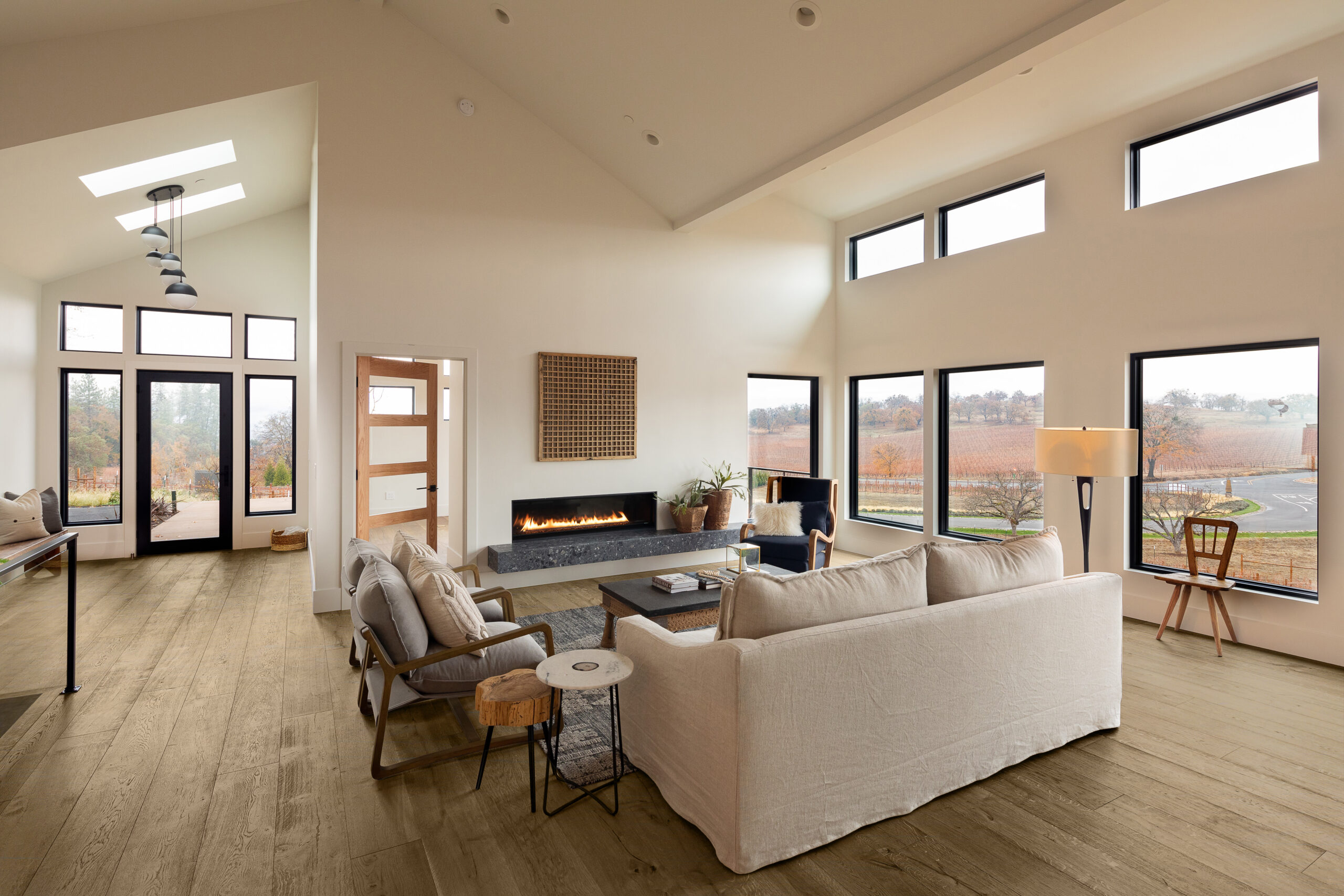 Bright, open living room with large windows and brown wood floor.