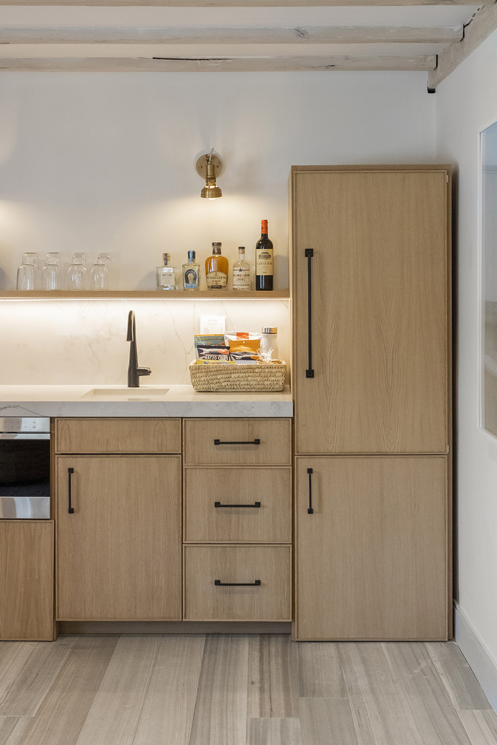 Wood colored refrigerator and cabinets with a wide plank modern flooring