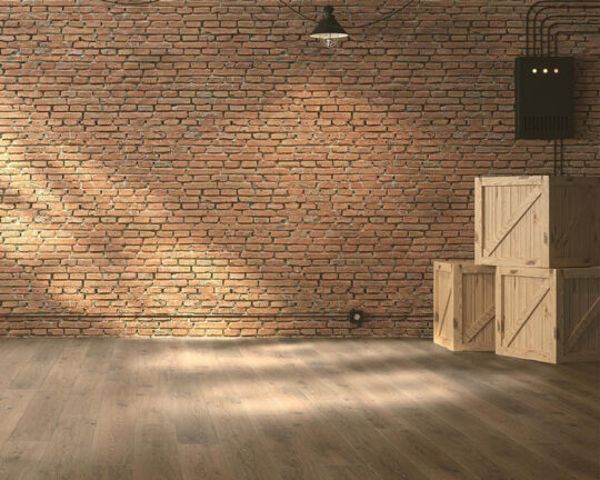 Unfurnished room with brick wall and wide plank wood floor.
