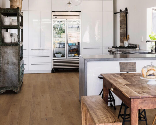 Rustic kitchen with natural wood table and clean lined wood floor.