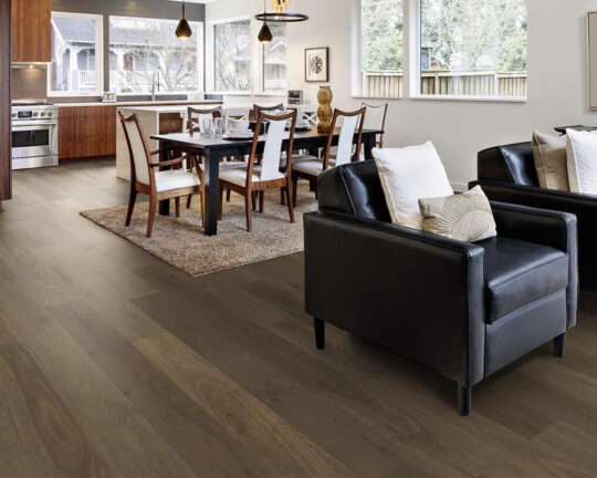 Dining and sitting area in a living space with dark colored wood flooring,