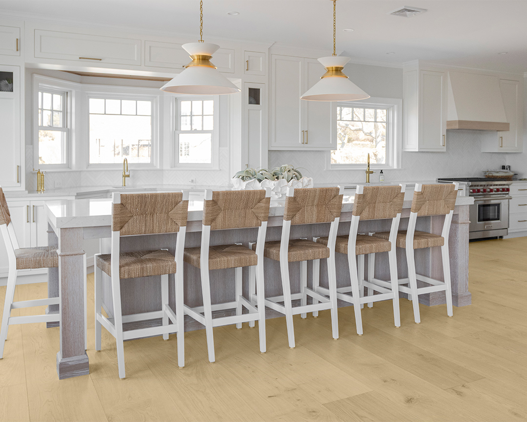 island seating in a bright neutral kitchen with white cabinets, walls, and light wide plank flooring
