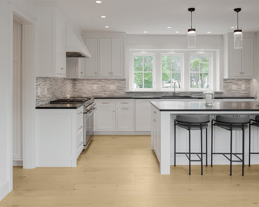 white kitchen cabinets kitchen island black countertops black furniture wood floors
