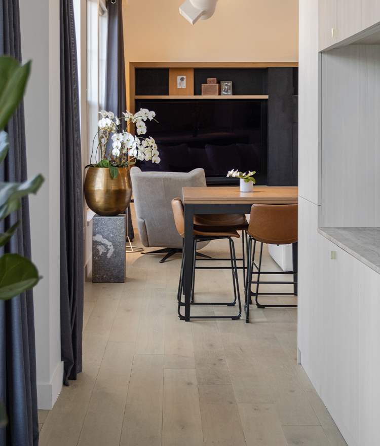 Modern dining nook in city apartment with light wood floor and decorative plants