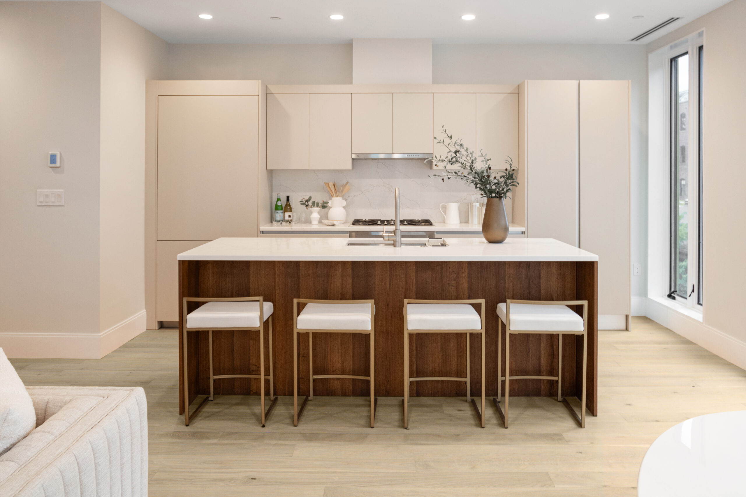 modern kitchen with white walls and neutral cabinets with dark wood island and light wide plank floors