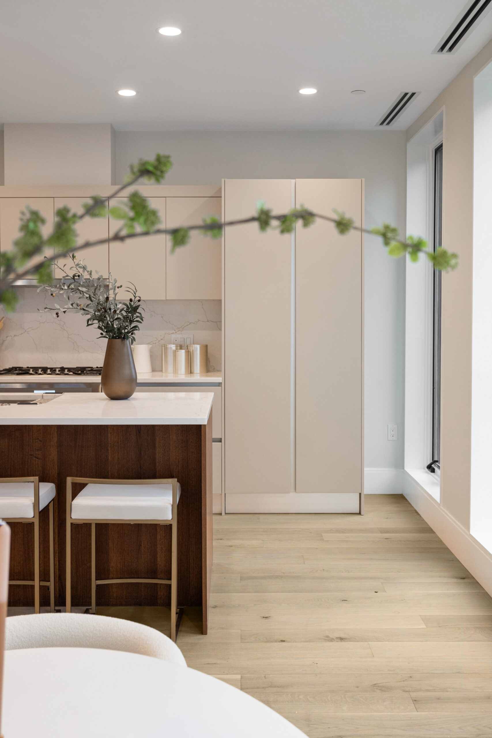 modern kitchen with white walls and neutral cabinets with dark wood island and light wide plank floors