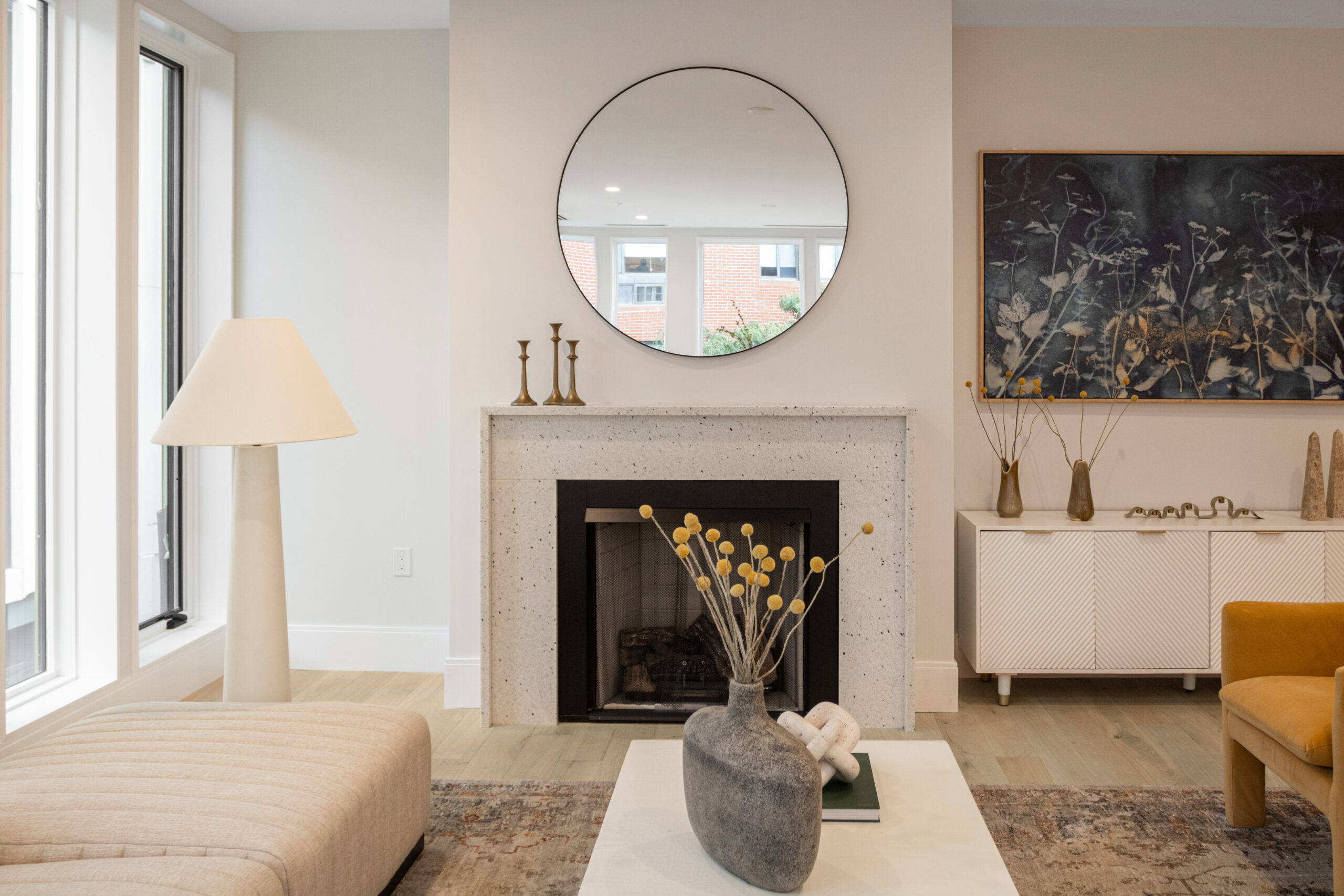 living room with fireplace and neutral toned walls and furniture and light warm wide plank floors
