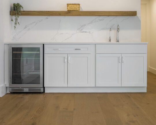 Warm tone natural brown floor in a contemporary home kitchen with white furniture